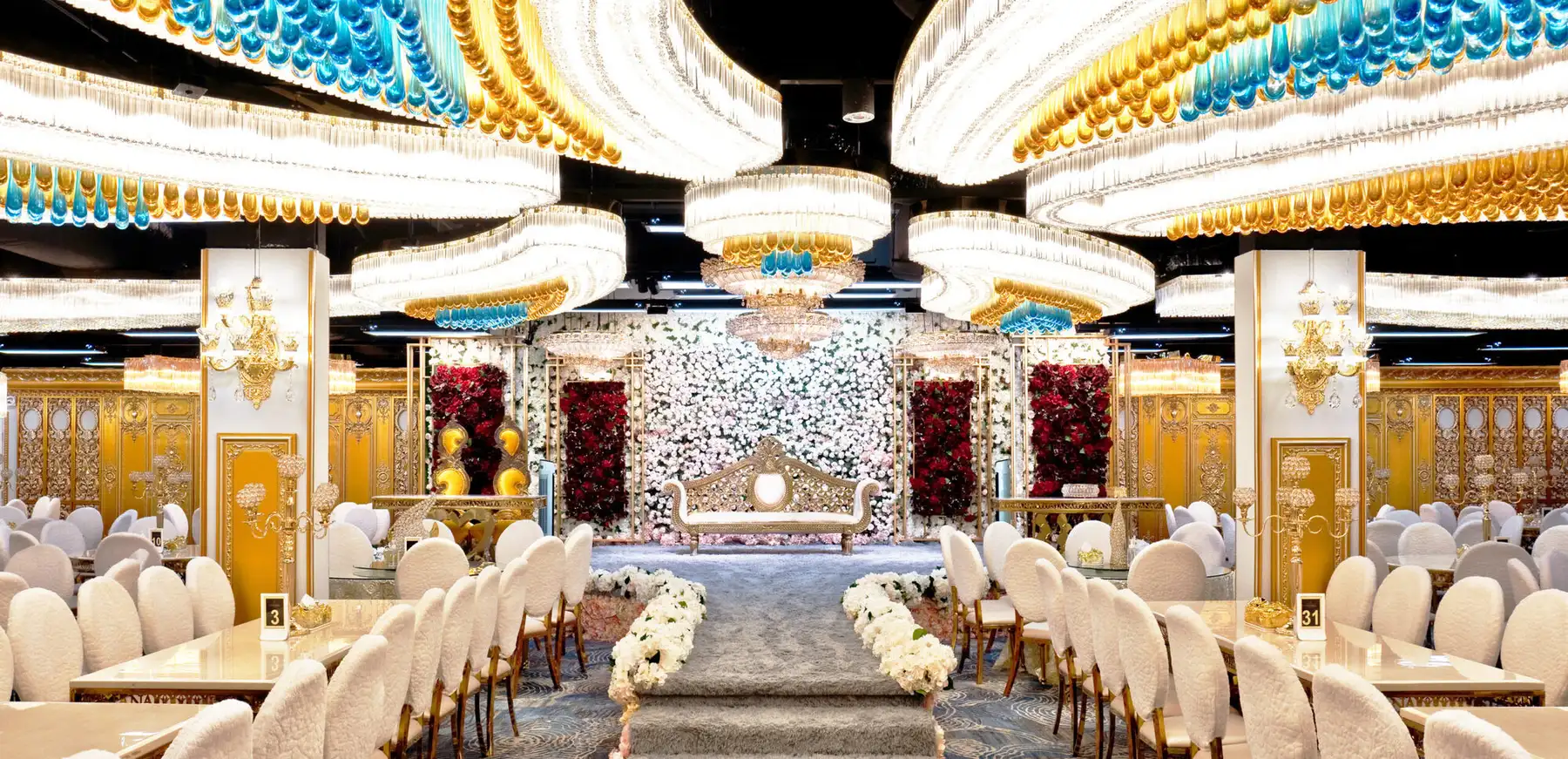 The Istana Ballroom set for a wedding, with chandeliers and a floral pelamin