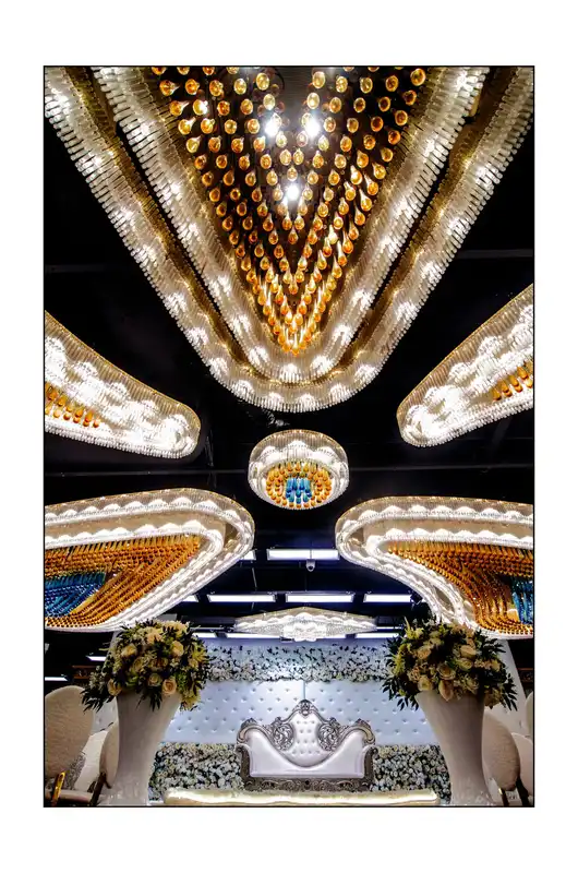 Chandelier above a silver tufted bridal dais