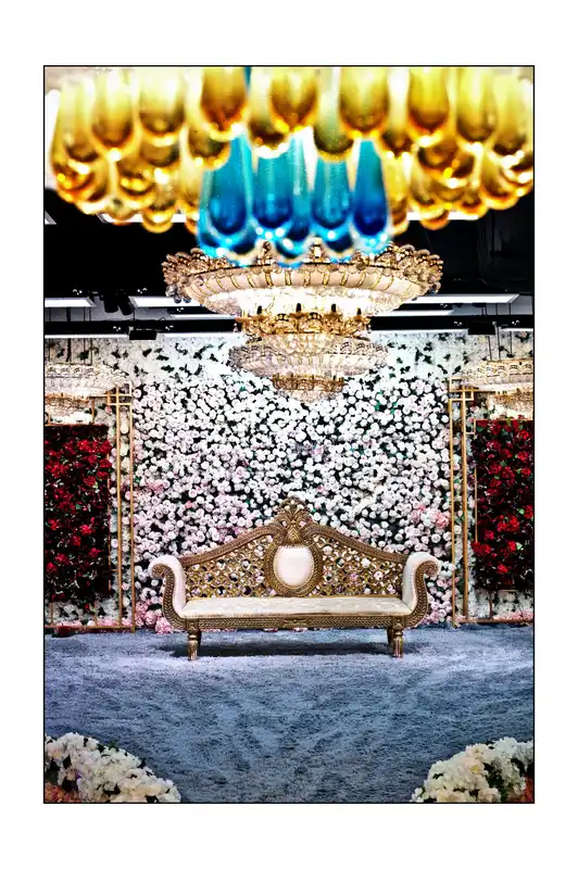 Carved gold loveseat with a white and pink flower wall