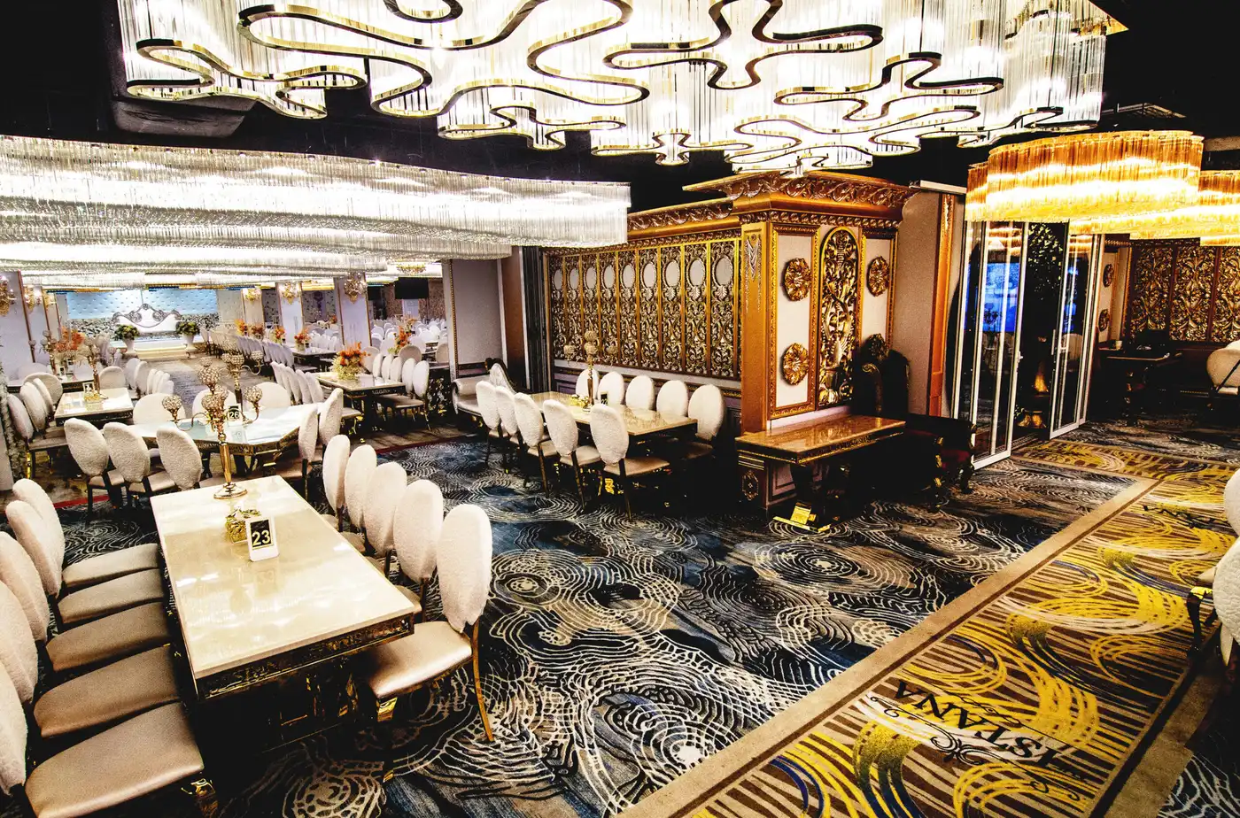 Long marble banquet tables set under the chandeliers